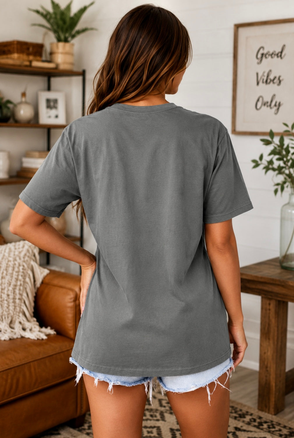 Woman wearing a gray t-shirt in a living room setting