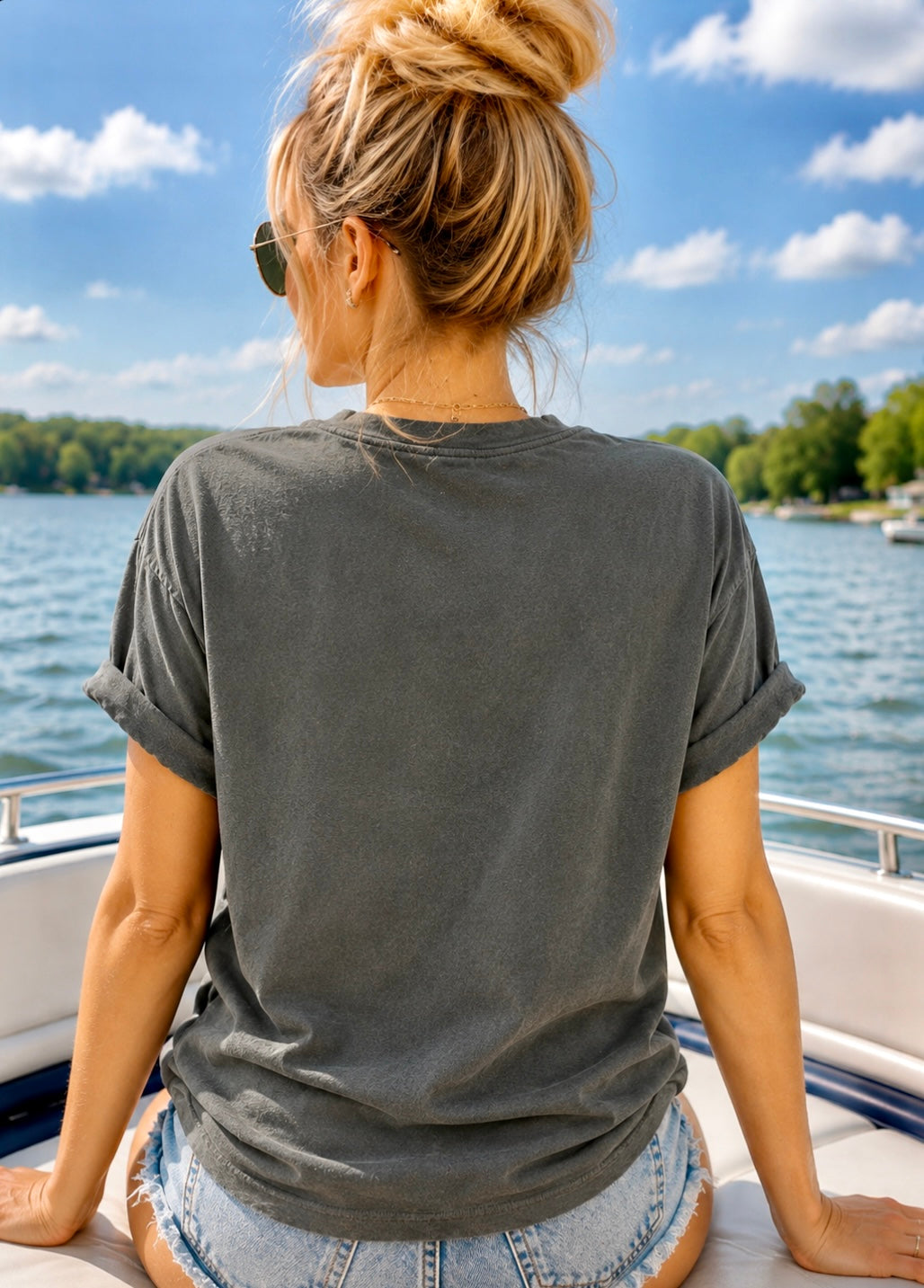 Woman sitting on a boat looking at a scenic view of water and trees.