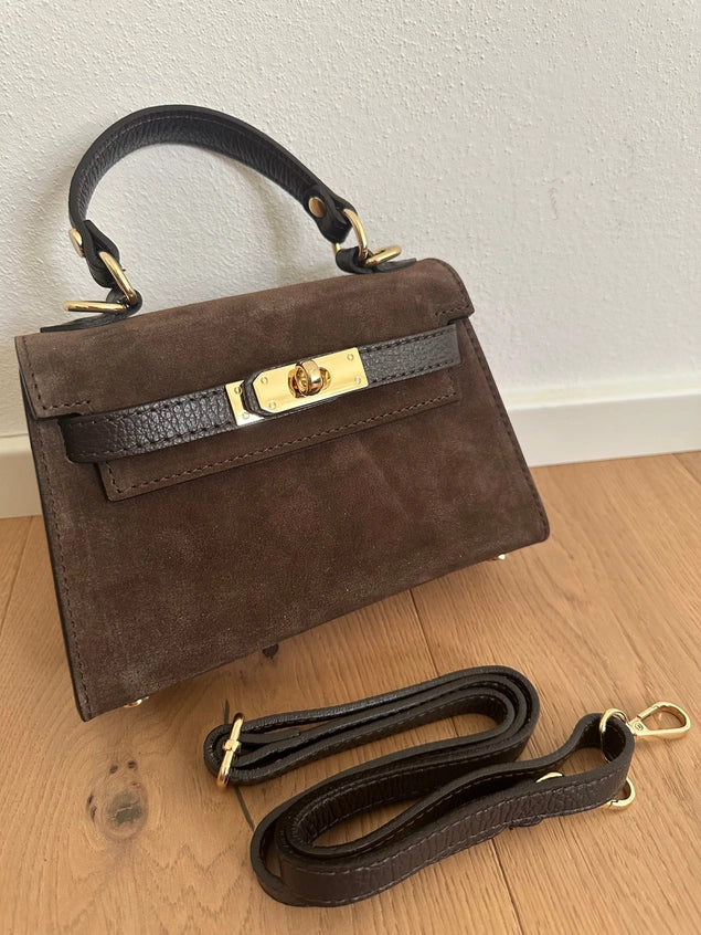 Brown handbag with a gold clasp on a wooden floor