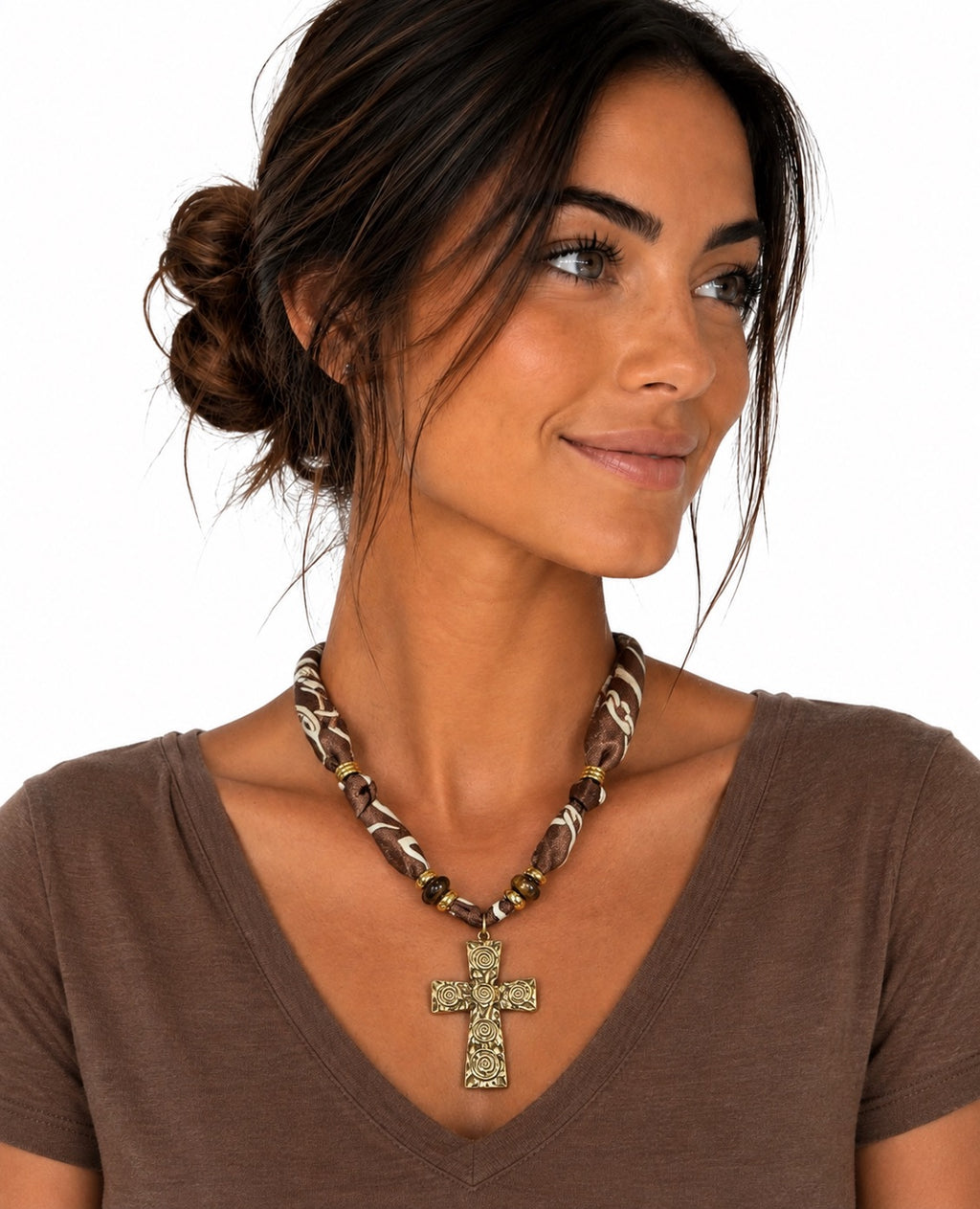 A woman wearing a chunky beaded necklace with a textured metallic cross pendant, shown from the chest up against a plain white background.