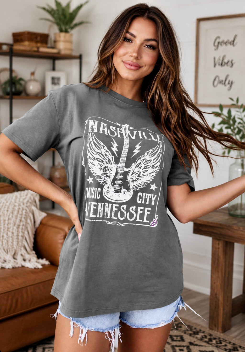 Woman wearing a gray t-shirt with 'Nashville Music City Tennessee' design in a living room.