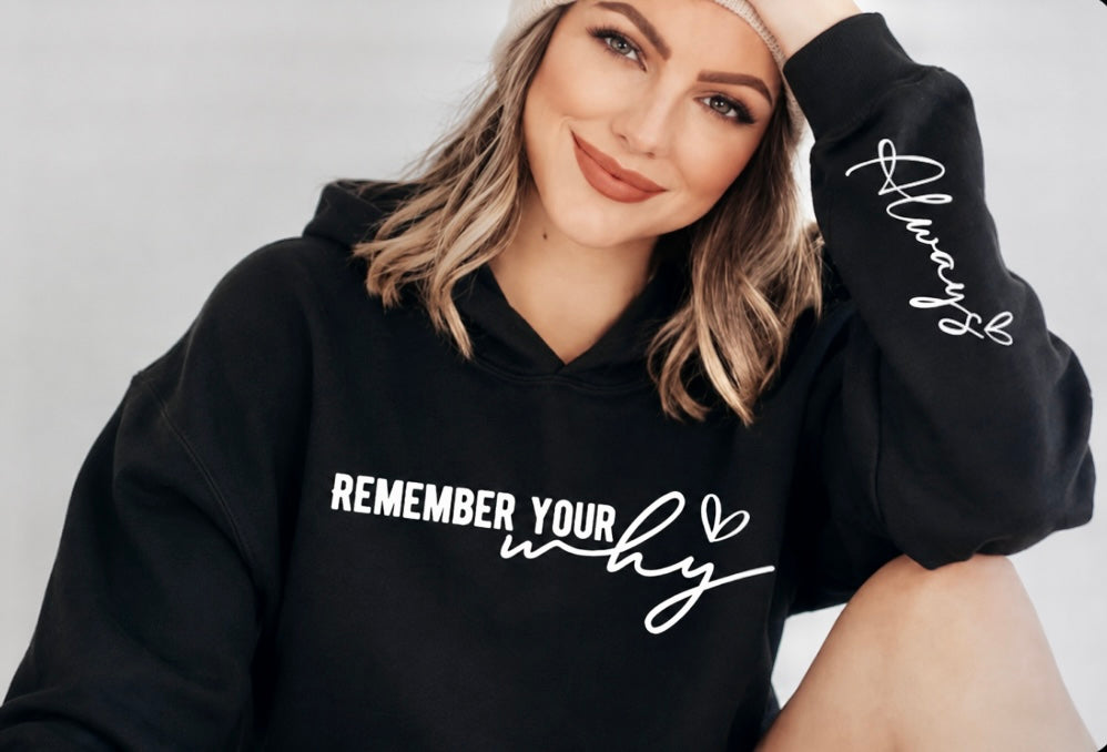 Woman wearing a black hoodie with 'Remember Your Why' text on a plain background