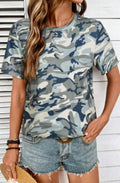 Woman wearing a camouflage t-shirt and denim shorts against a white wooden background