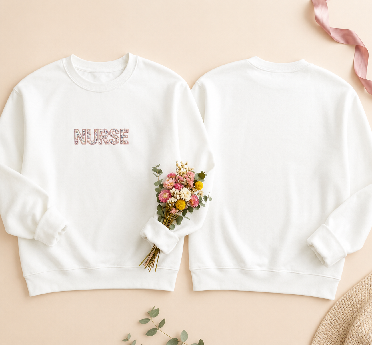White sweatshirt with 'Nurse' and 'Nurse Mom' text, accompanied by a bouquet of flowers on a beige background.
