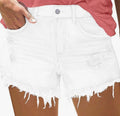 White denim shorts with frayed edges worn by a person, with a pink shirt partially visible.