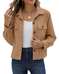 A woman wearing a cropped, ribbed knit button-up jacket in a warm camel tan color, styled over a white tank top and blue jeans with a white background.