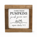 Square wooden sign with a white insert featuring the text 'FARM FRESH PUMPKINS pick your own open daily 9-3' and simple pumpkin illustrations, shown on a light gray background.