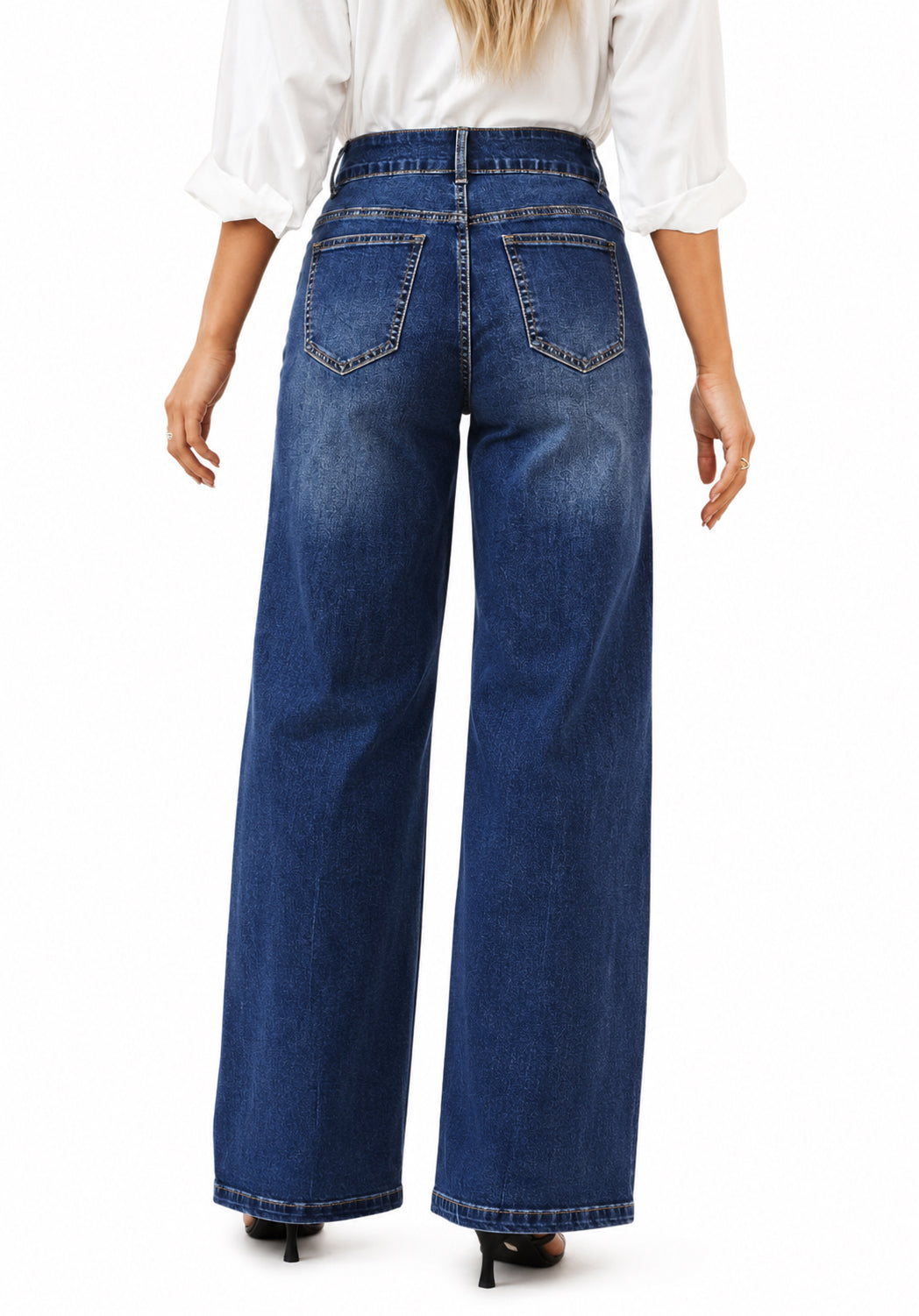 A person shown from the back wearing high-waisted, wide-leg blue denim jeans with a white blouse and black heels, against a plain white studio background.