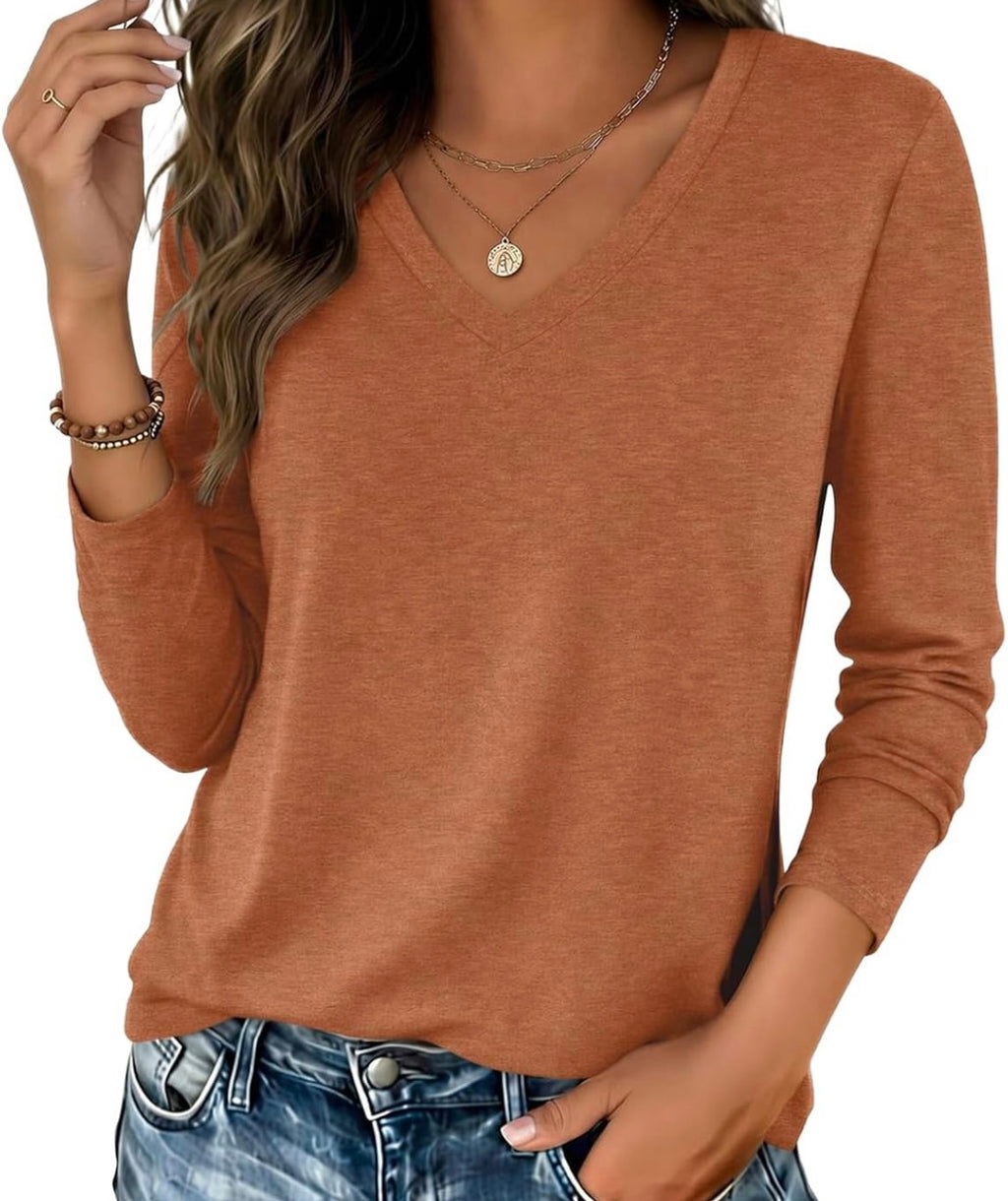 A woman wearing a rust-orange long-sleeve V-neck top and blue jeans, shown from the shoulders to the hips against a plain white background.