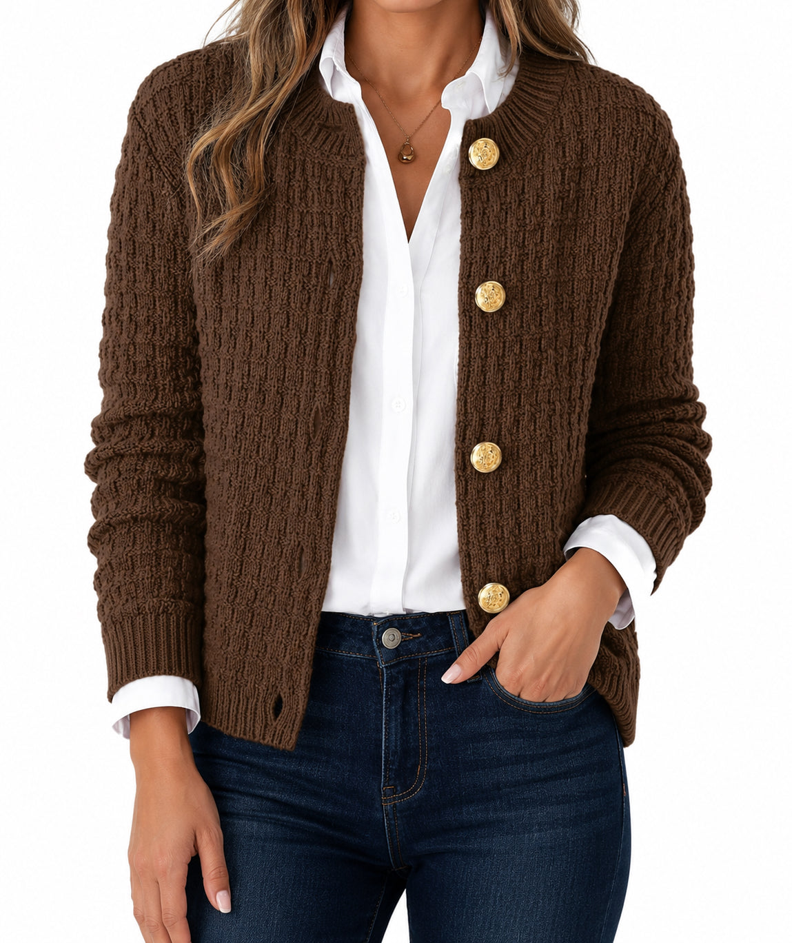 A woman wearing a brown cable-knit cardigan with gold buttons, layered over a white collared shirt and paired with dark blue jeans, shown against a plain white background.