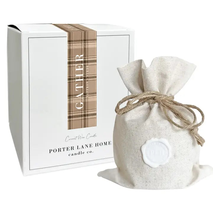 A white rectangular candle box with a vertical tan plaid band reading 'GATHER' and 'Porter Lane Home Candle Co.' stands beside a small natural linen drawstring pouch with a white wax seal, on a white background.
