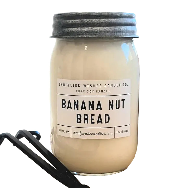 A glass jar candle filled with creamy off-white wax, sealed with a dark metal lid, and labeled 'Banana Nut Bread' by Dandelion Wishes Candle Co. with a white background.
